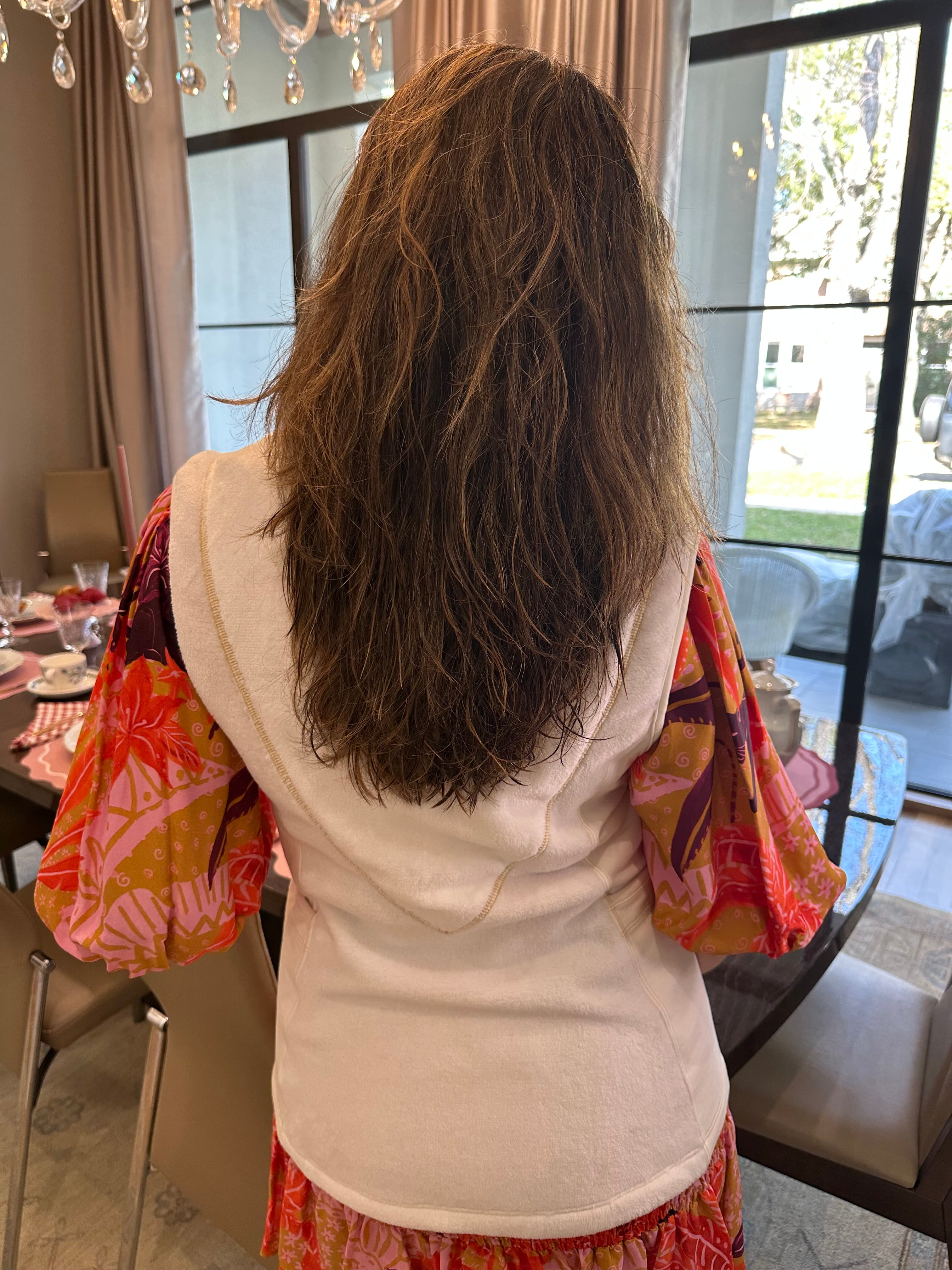 A woman with long hair wearing the post shower vest
