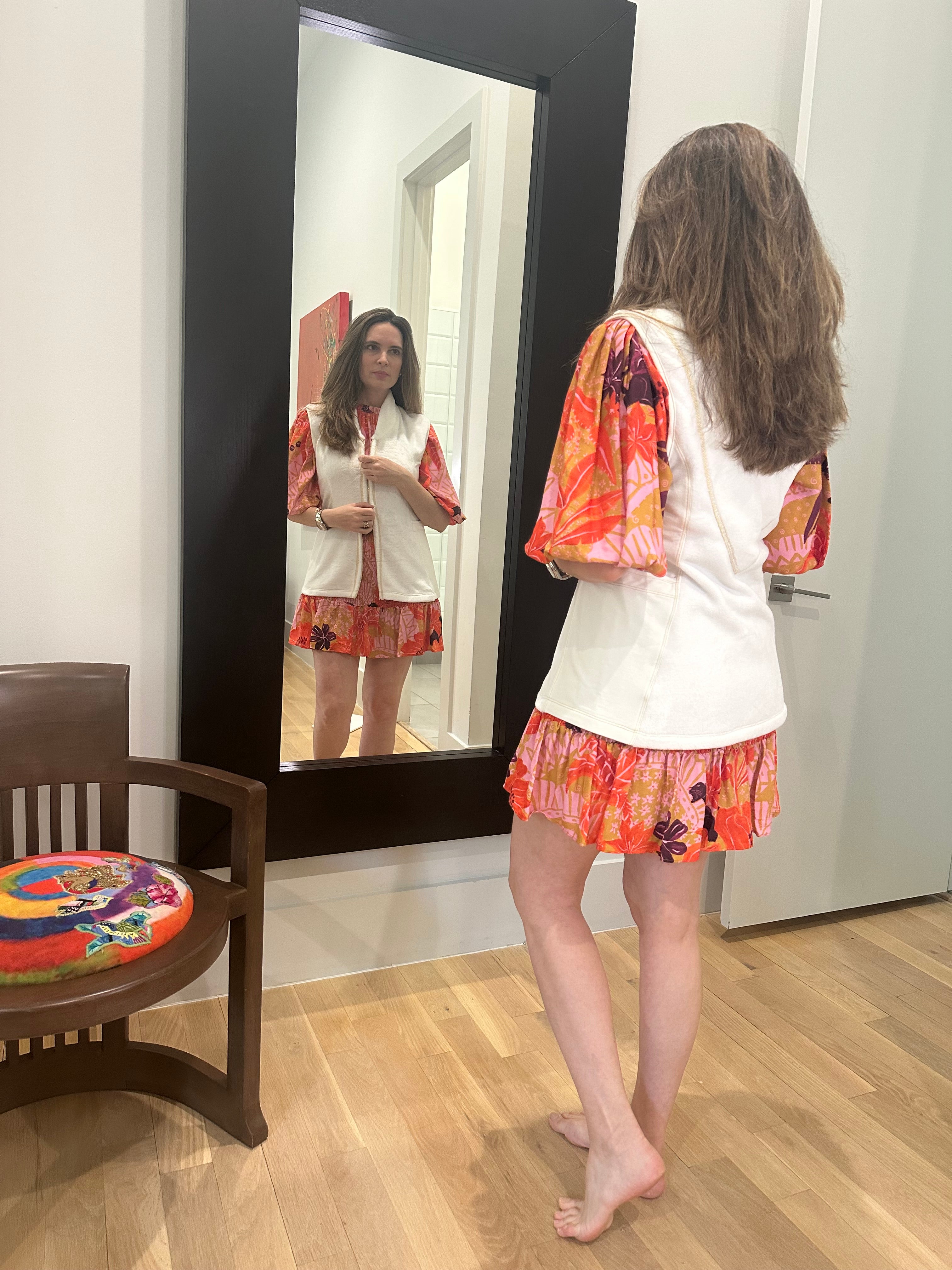 A girl with long hair wearing the post shower vest on top of her dress