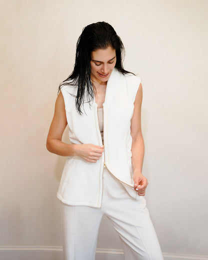 Woman wearing a post shower vest PSV against a plain background