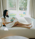 Woman lounging in RoMia24 luxury robe alternative on couch
