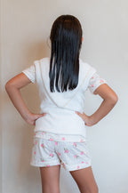 girl with wet hair wearing vest as a robe alternative to protect her pijamas from being wet from her damp hair