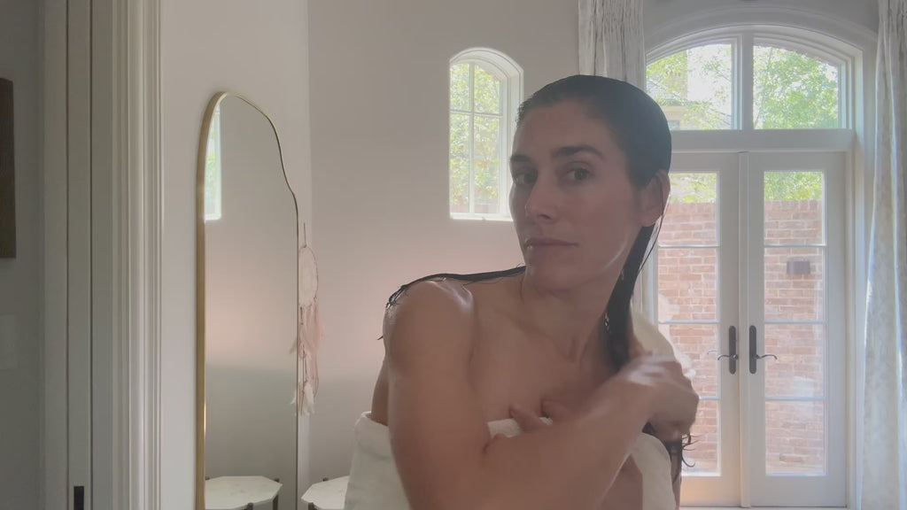 Woman doing skincare wearing the luxury post shower vest
